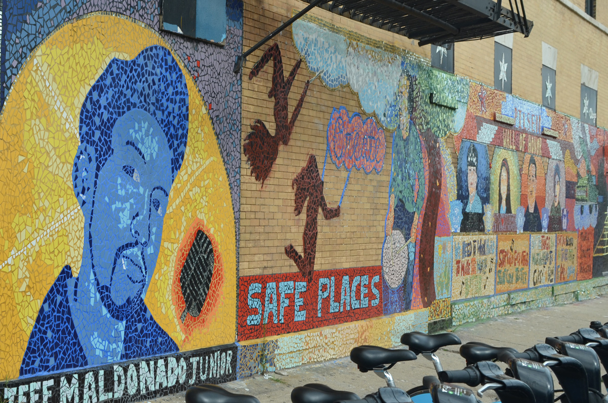part of a mural at 18th and Paulina in Pilsen area of Chicago, by J-DEF peace project, a portrait of Jeff Maldonado Jr. for whom the project is named after, as well as a picture with the theme of create safe places away from gun violence 