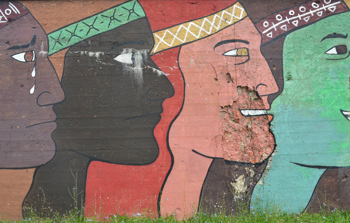 mens faces in profiles in different colours, large, about 10 feet tall, mural on a wall beside the railway tracks in Pilsen Chicago, Galeria del Barrio
