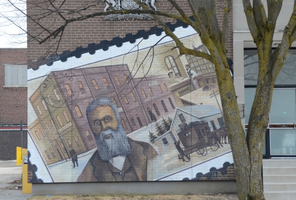 picture of man with grey hair, beard & mustache standing outside the post office, 