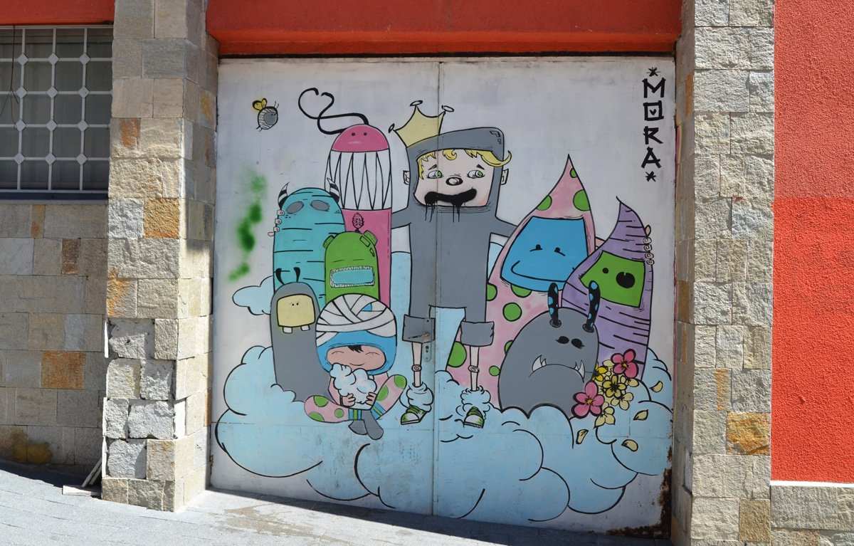 small mural of a group of cartoon-like characters standing on a blue cloud, signature is mora. 