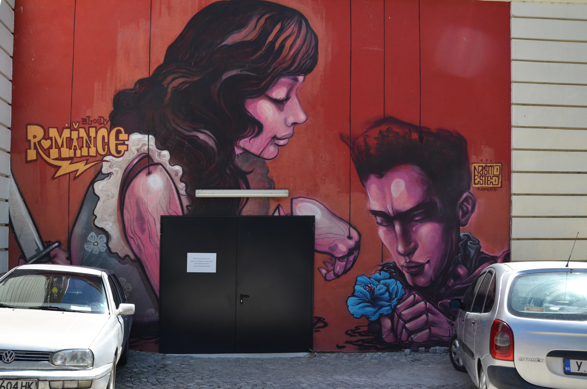 the story of romance, a mural by ernesto nasimo of a man giving a blue flower to a woman with shoulder length brown hair, on a red background 