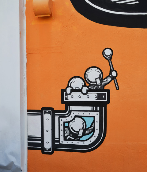 a pipe comes out of a wall, painted on a mural, small astronaut characters are coming out of the pipe