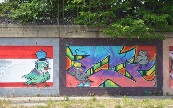 two murals on a wall, both with birds