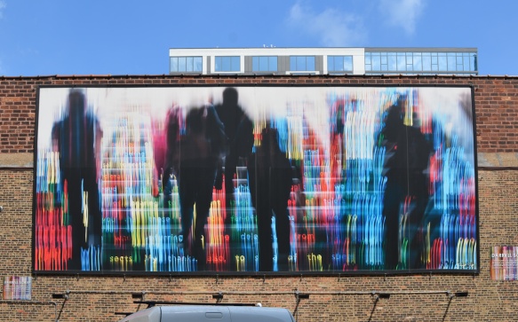 mural on a wall, black people in silhouette walking towards numbers in LED lights that look digital