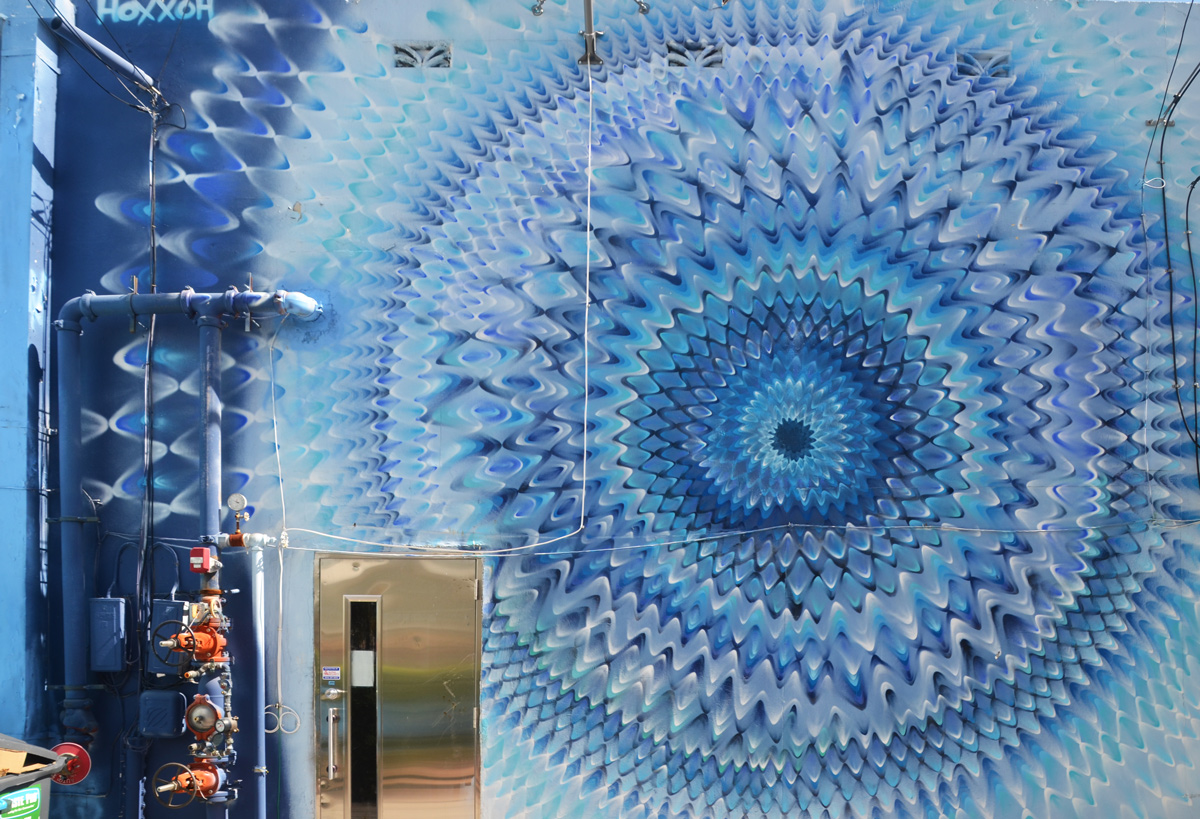mural by hoxxoh of blue circles or pulsating waves on a wall 
