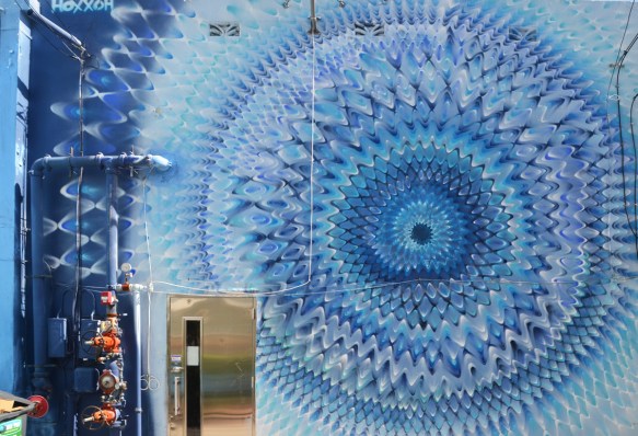 mural by hoxxoh of blue circles or pulsating waves on a wall 