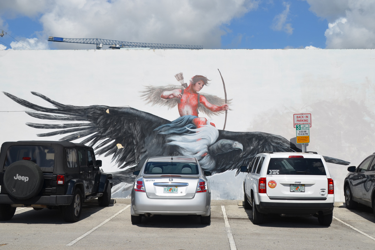 a man riding on the back of a verylarge vulture, he has a bow in his hand and is shooting arrows 
