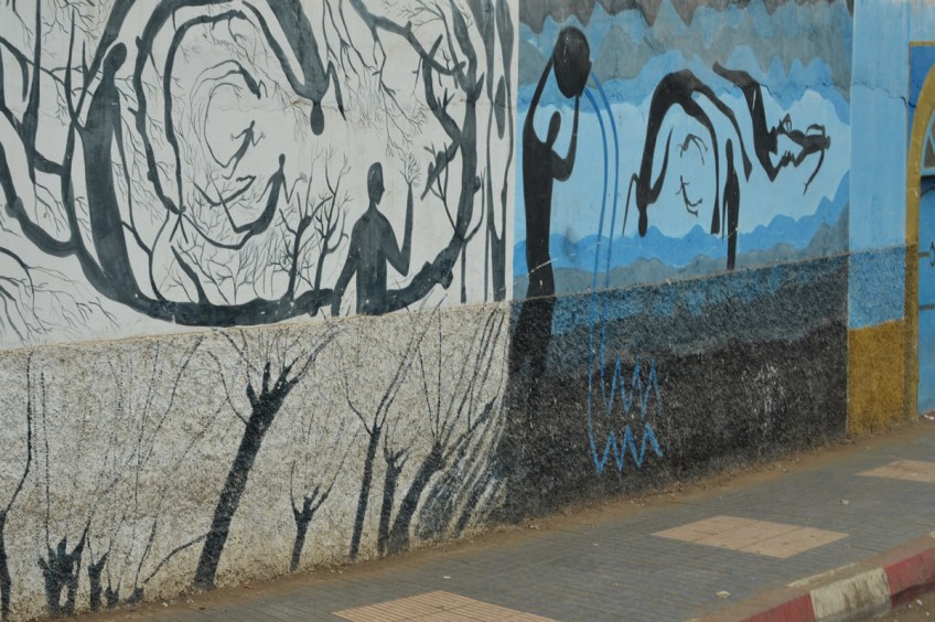 part of a series of murals on a Casablanca wall - whimsical people doing athletic thigs,