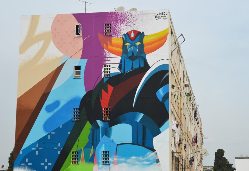 in a residential area of apartment buildings, a large mural by med, closer look