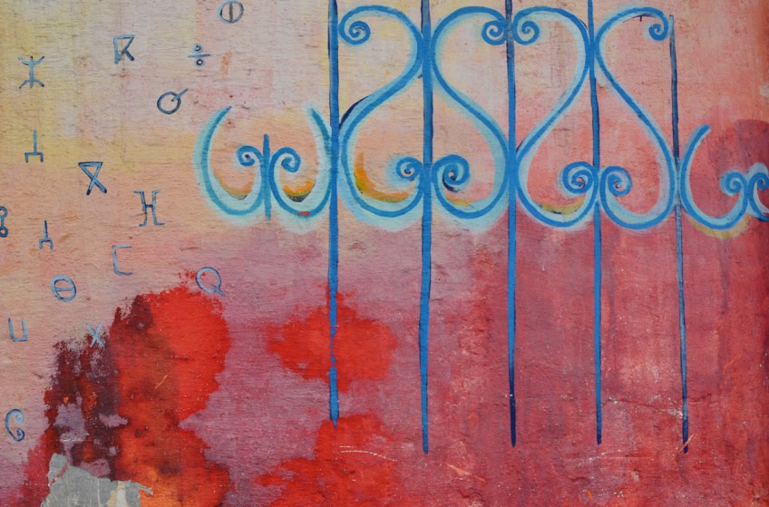 part of a series of murals on a Casablanca wall, in blue curly shapes as seen on many metal railings in Morocco, on a red and orange background
