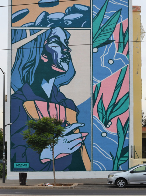 large mural by ndzw on the side of a Casablanca residential building in Derb Ghallef 