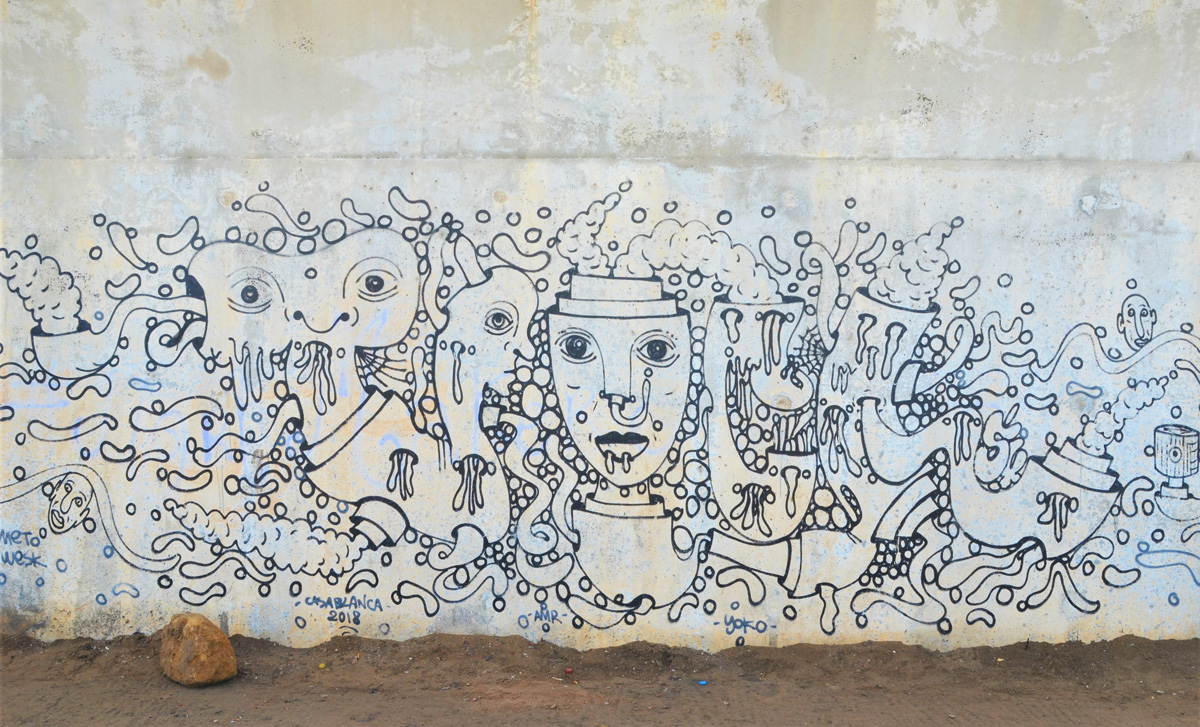 black line drawing mural on a wall, with faces
