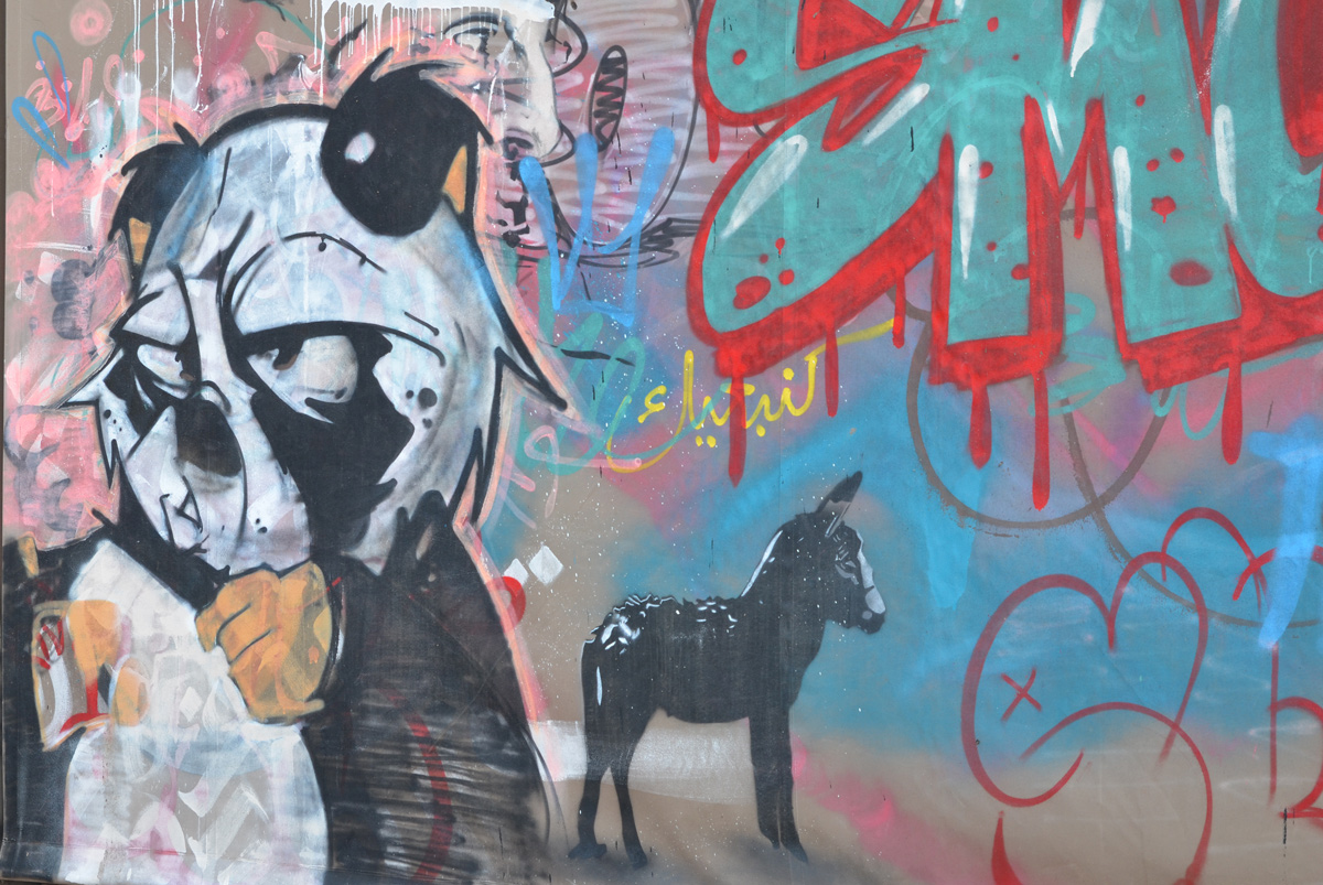 a small black horse and a face in profile in a mural