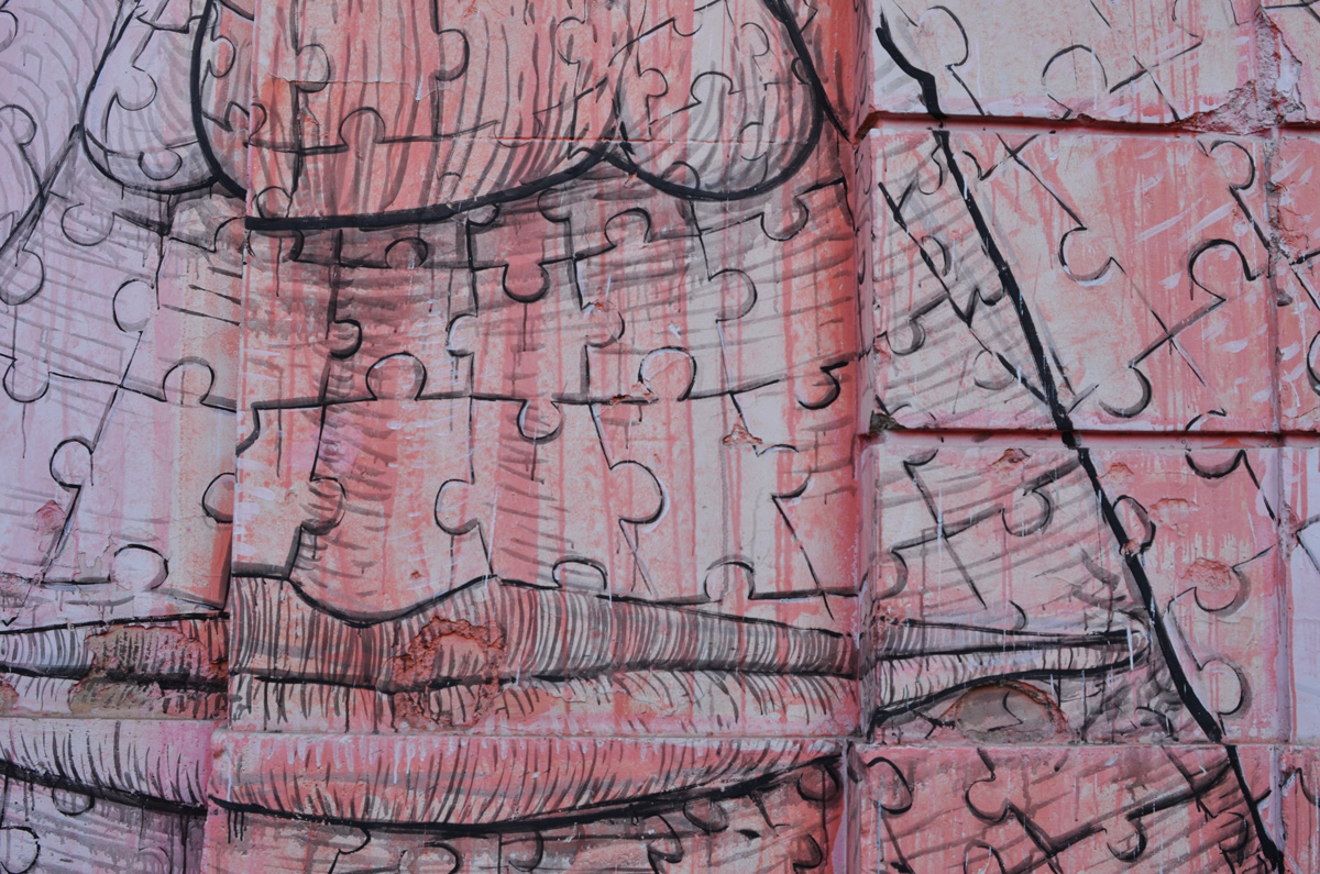 mural in Rome by Blu, on del porto fluviale, of large faces, where the eyes are windows in the buildings, close up of red face made up of puzzle pieces