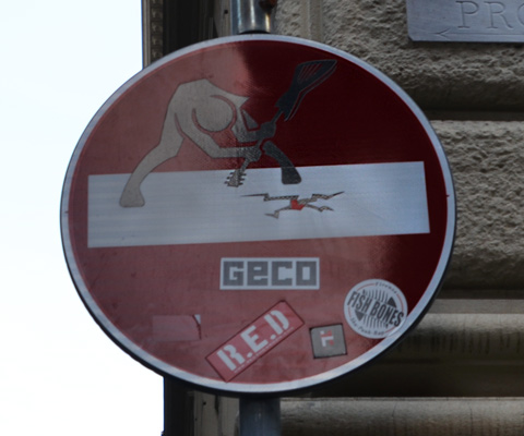 altered red and white no entry sign, graffiti by Clet Abraham, of a person breaking ice with a large ice pick