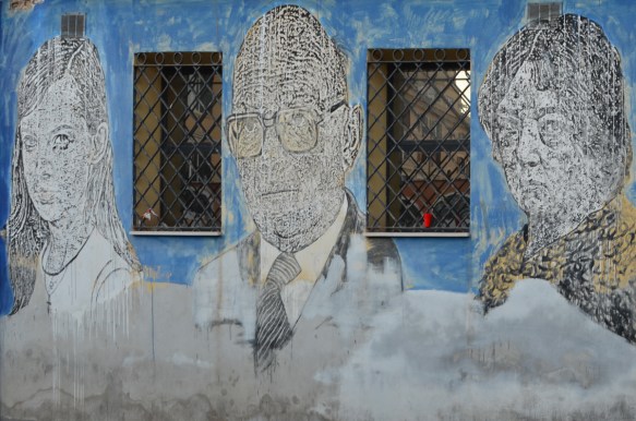 girl, middle aged man, woman, large portraits by sten and lex, Italian street arts, in a mural on two sides of the street, of famous people and common people,