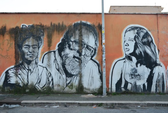 three people, large portraits by sten and lex, Italian street arts, in a mural on two sides of the street, of famous people and common people,