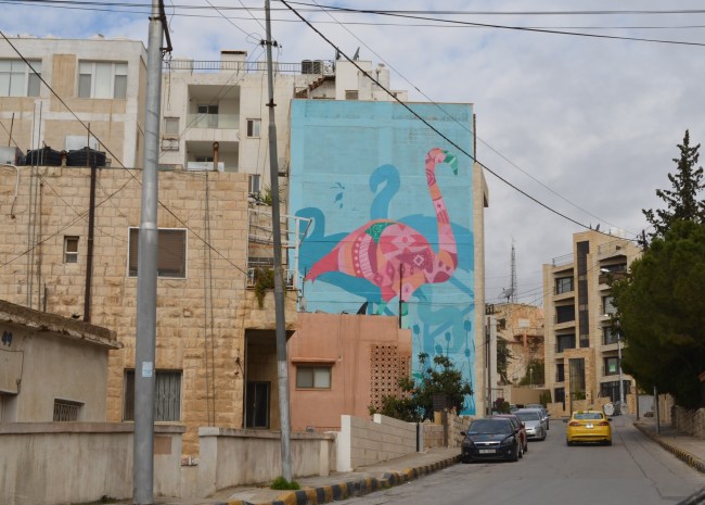 large mural of a pink flamingo seen from down the street