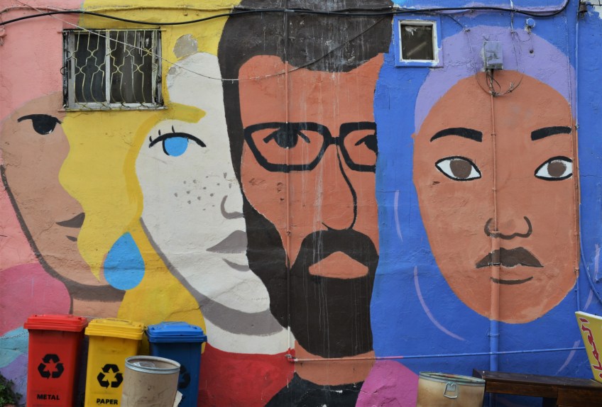 mural of large faces by the Orenda Tribe