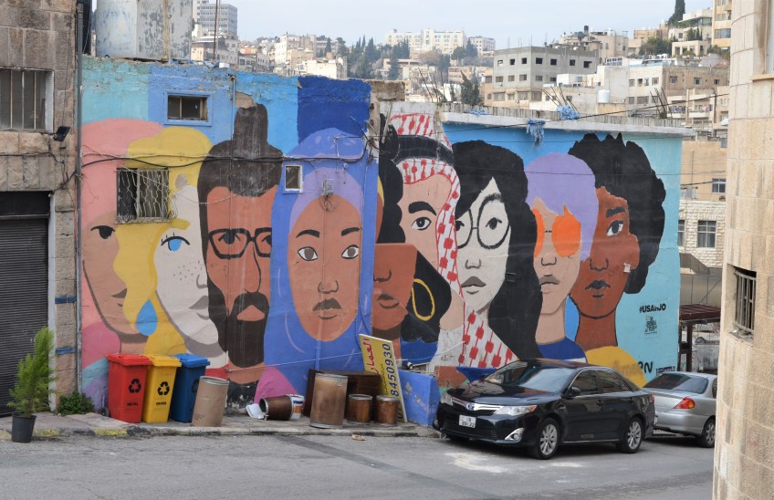 mural of a line of large faces of different ethnic backgrounds, and colours,