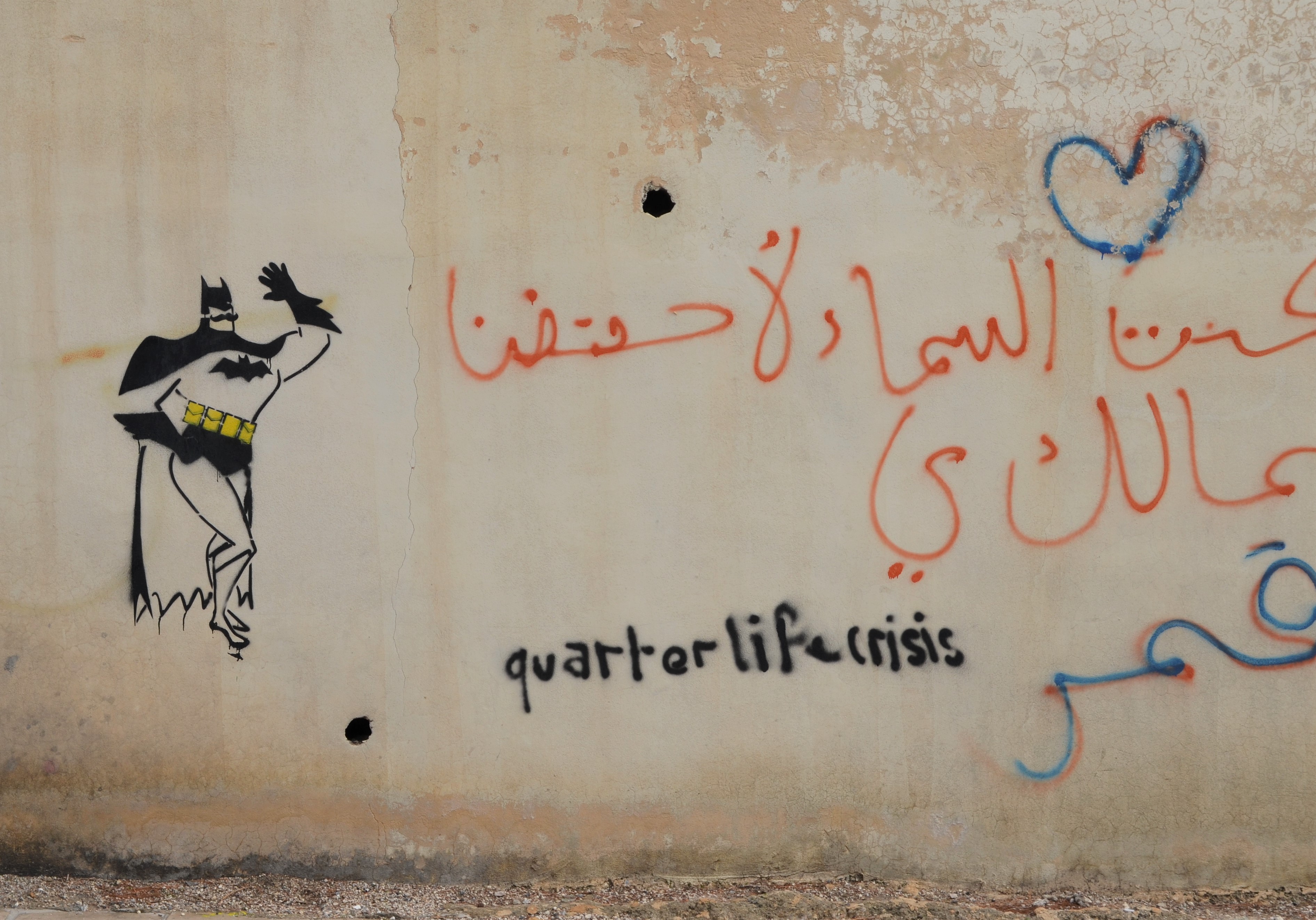 Batman stencils on a wall along with words that someone has written, quarterly life crisis 
