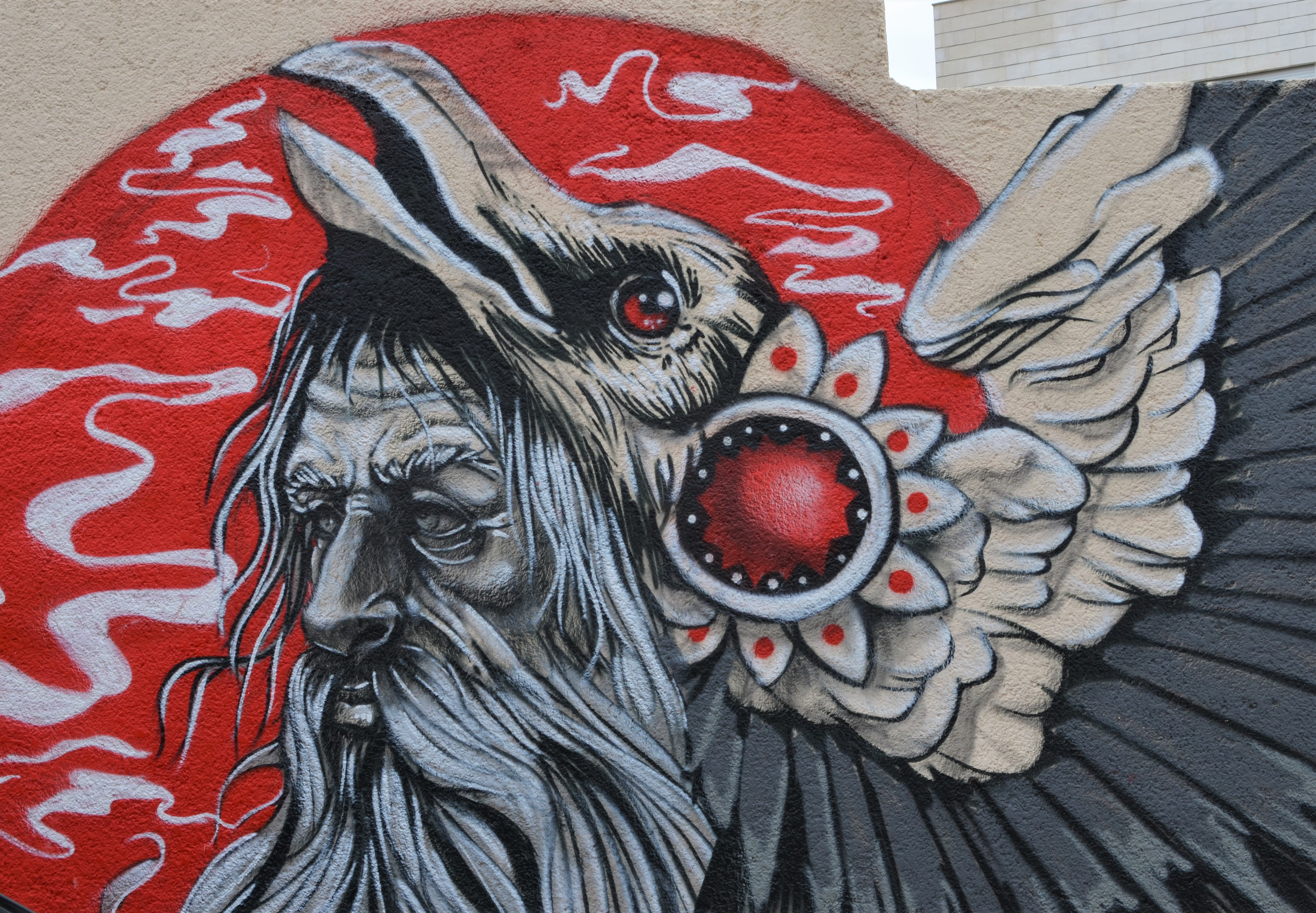close up of head of bird in mural by Suhaib Attar in grey tones on red background