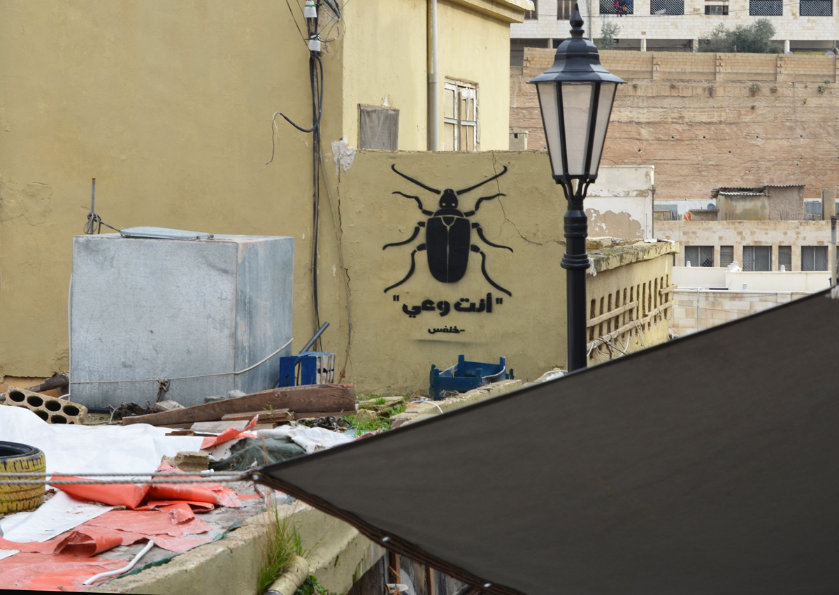 black stencil of a large building over the rooftops of Amman