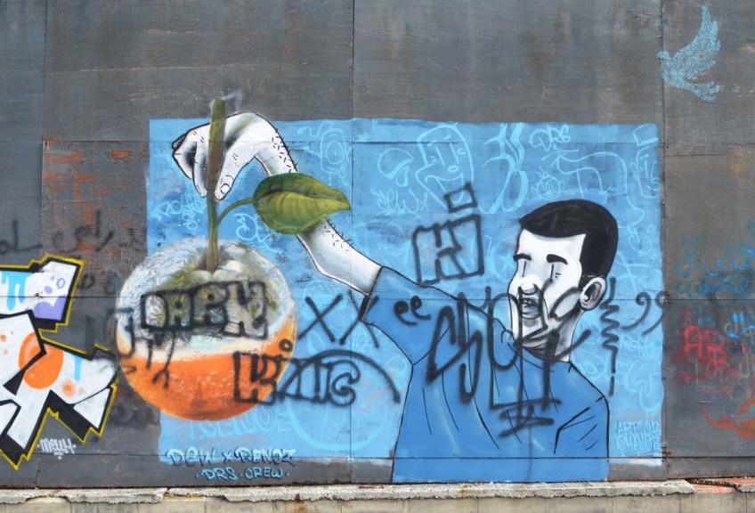 On blue background, a young man holding up a large rotten orange, holding by the stem, street art by Dew and renoz