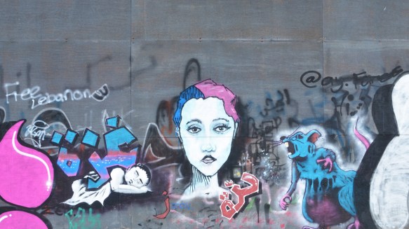 a woman's face with hair half blue and half pink, a large blue mouse that is screaming 