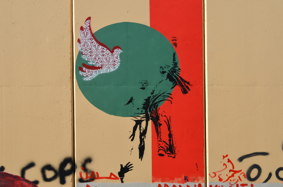 black stencil of two people looking into the distance, on top of a green circle along with a red and white dove
