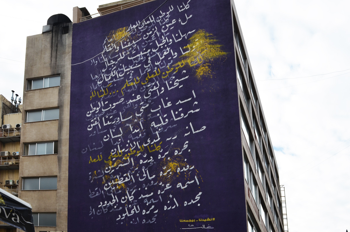 large mural on the side of a building in Hamras Beirut, purple background with white Arabic writing on it 