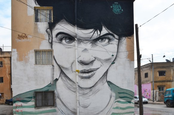 fontal portrait of a person with short black hair and green eyes