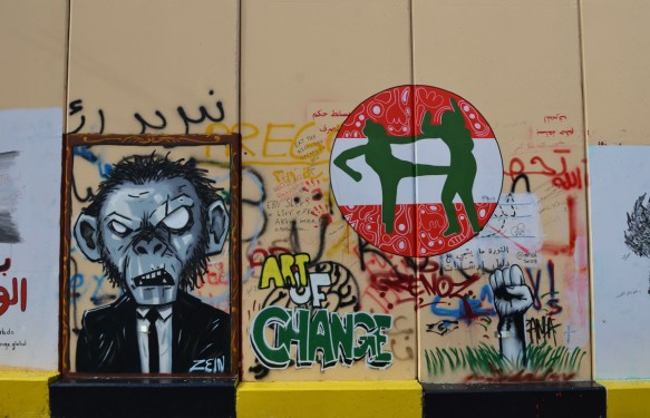 graffiti, a man with a monkey face, a red and white do not enter sign with two green figures fighting, 