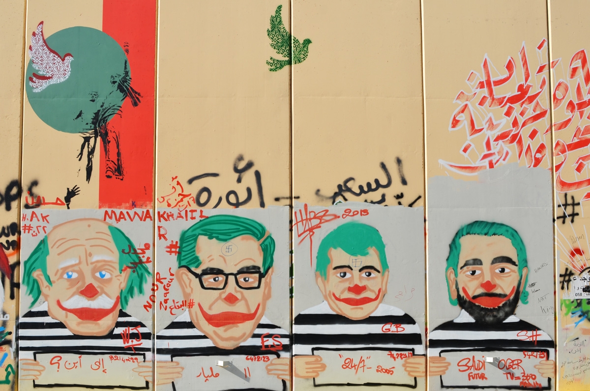 graffiti on a Beirut wall, caricature mug shos of 4 Lebanese men, green hair and clown mouths, wearing black and white striped tops