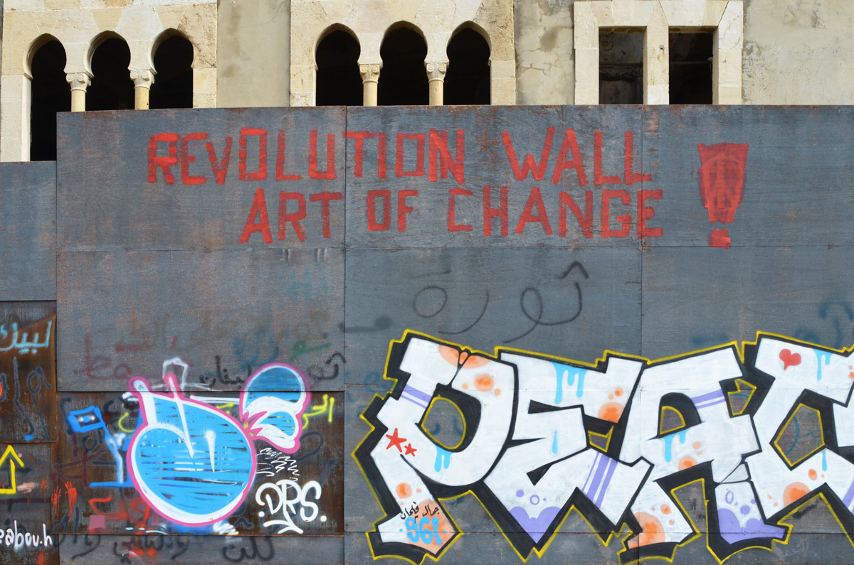 on a grey wall in red letters, Revolution Wall Art of Change, peace written as a tag,