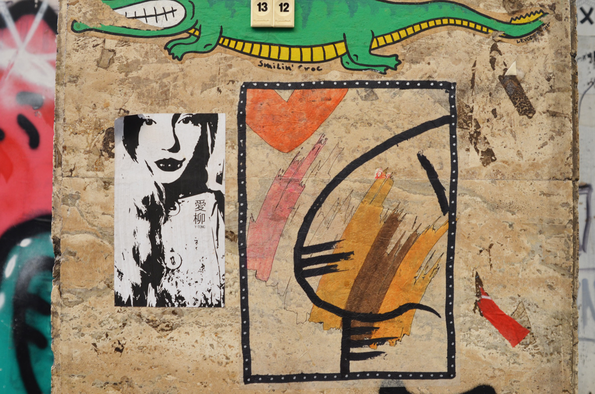 smilin croc graffiti as well as a big nose by K 2 M, also a black and white pasteup of a woman