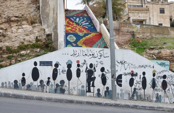 a white wall with paintings of people made from circles and ovals with stick arms and legs, all doing something, climbing ladder,