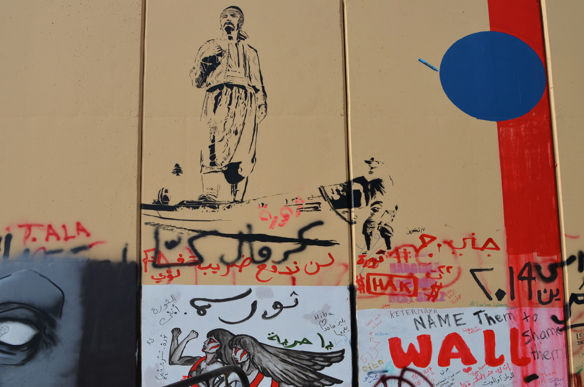 stencil of a man in arab dress walking and other graffiti 