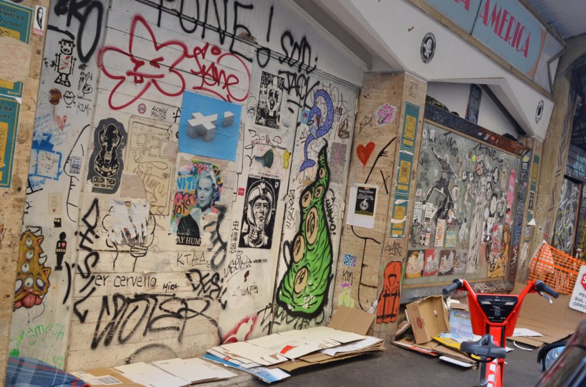 a wall covered with stickers and pasteups