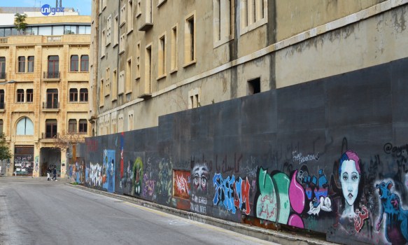 grey wall in front of office building, with street art on the wall, Beirut