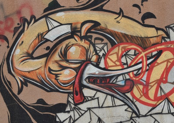 mural with a yellow duck with its white beak open and white paper boats all around 