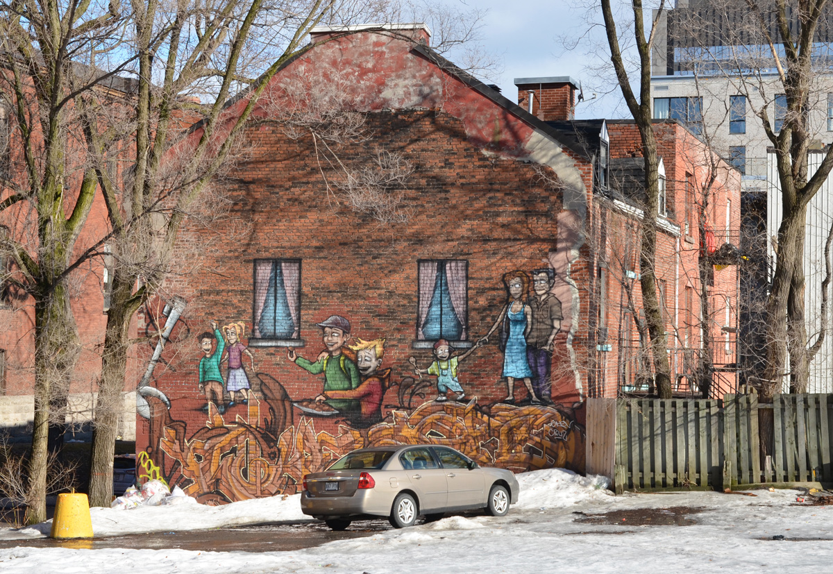 on the end of a brown brick building, a mural of people walking on large noodles that are coming out of a very large ladle 