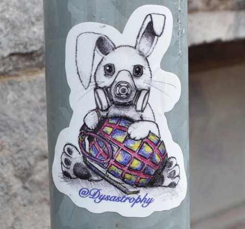 liittle sticker on a grey metal pole, a rabbit in a gas mask holding a hand grenade, dystrastrophy stcker