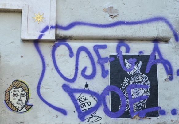 black and white cat poster paste up by guaro and a jesus head with the words tifa toro 