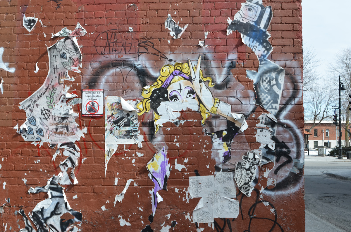 left over bits and pieces of paste ups on a wall, paper, torn, weathered, 