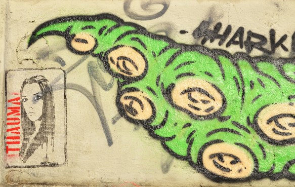 a long green lizard tail graffiti with a picture of a woman thauma beside 