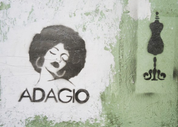 portrait of a woman, stencil in black, eyes closed, head tilted, round head of hair, words say adagio, also a stencil of a dressmaker's form 