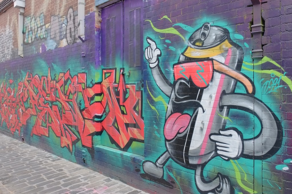 mural thati includes a large spray paint can with arms, legs, a mouth and a very big red tongue