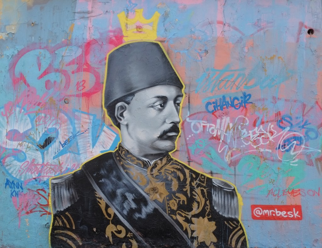 street art mural by Turkish artist mr besk of an official looking Turkish man wearing a fez
