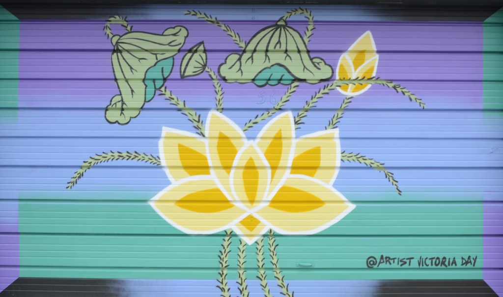 garage door mural by Victoria Day, stylized yellow and green flowers on a blue green gradient background